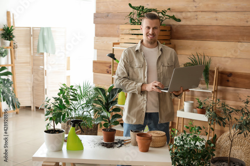 Young gardener with laptop ...