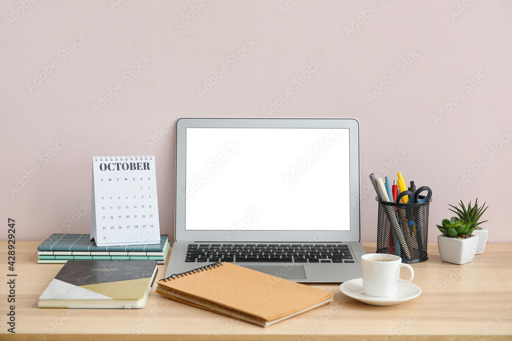 Flip paper calendar with laptop, cup of coffee and stationery on table Flip paper calendar with laptop, cup of coffee and stationery on table