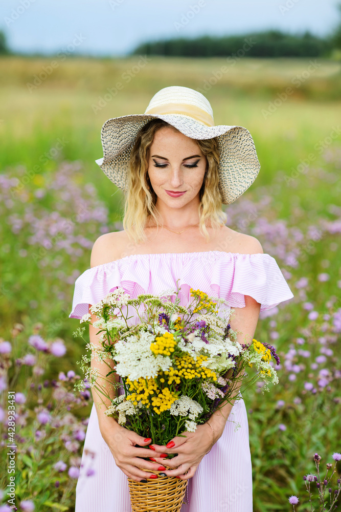 Portrait of a young woman with a bouquet of wild flowers.