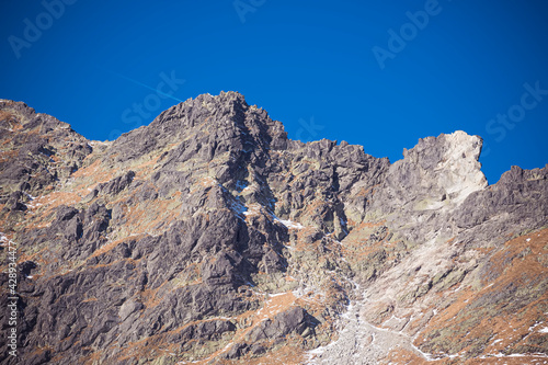 Crags between Świnica Peak and Zawrat Pass, High Tatra Mountains, Poland. An old trail can be seen in the distance. Selective focus on the ridge, blurred background.