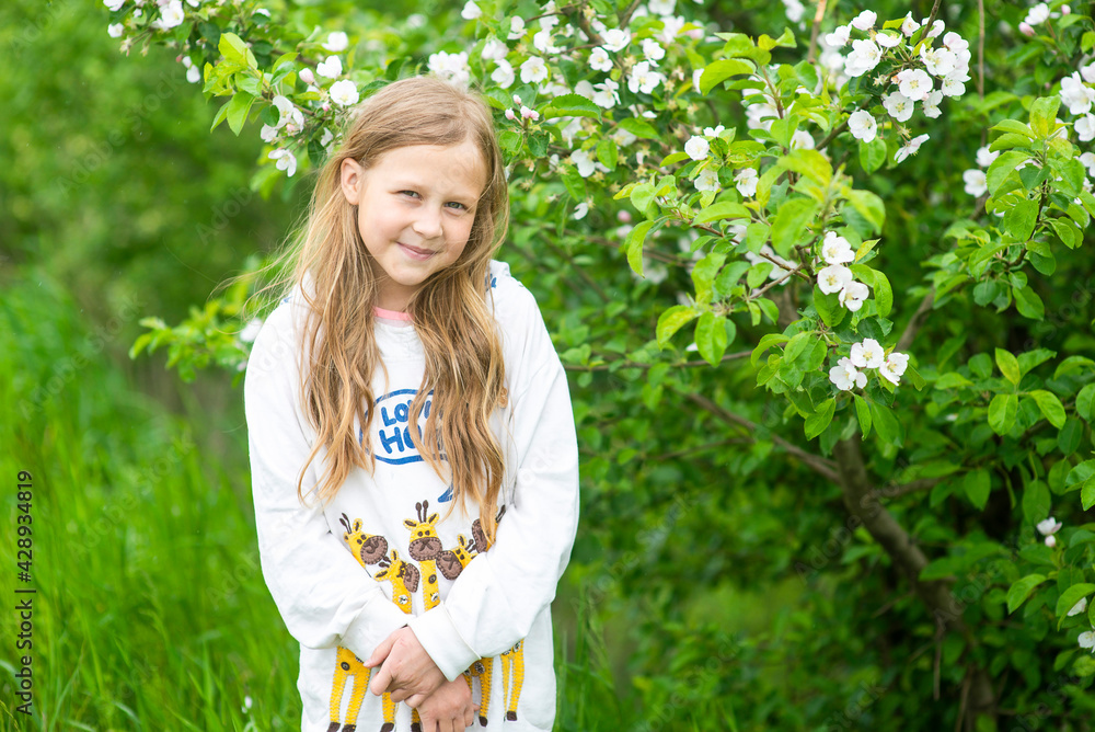 Happy girl playing in spring blooming apple orchard, selective focus Happy girl playing in spring blooming apple orchard, selective focus