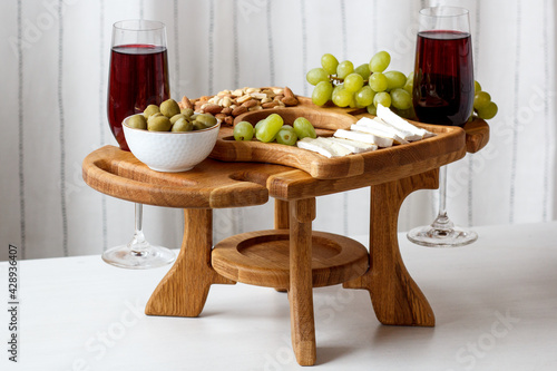 Serving wooden table for wine, glasses and snacks. Handmade segmented Portion wooden table. Grapes, cheese, wine and nuts.  