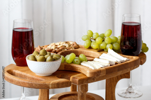 Serving wooden table for wine, glasses and snacks. Handmade segmented Portion wooden table. Grapes, cheese, wine and nuts.  