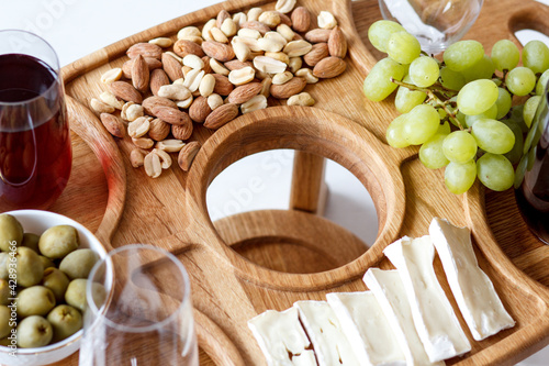 Serving wooden table for wine, glasses and snacks. Handmade segmented Portion wooden table. Grapes, cheese, wine and nuts.  