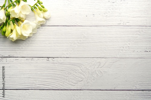 Floral background mockup, wedding, spring concept, white flowers on white washed wood background, space for text or product presentation.