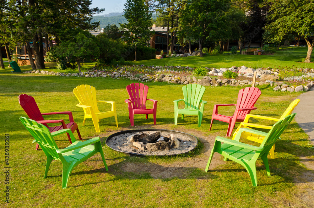 outdoor fireplace with three colorful chairs