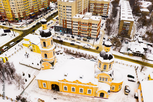 Aerial view of historic two domed building of Orthodox Cathedral of Intercession in Penza on background with modern residential area on winter day, Russia © JackF
