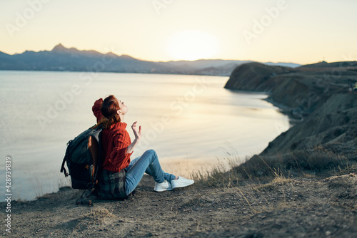 a traveler with a backpack on the sand relaxes in nature near the sea in the mountains