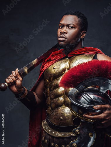 Fotografija Proud roman warrior of african descent holding gladius on his shoulder