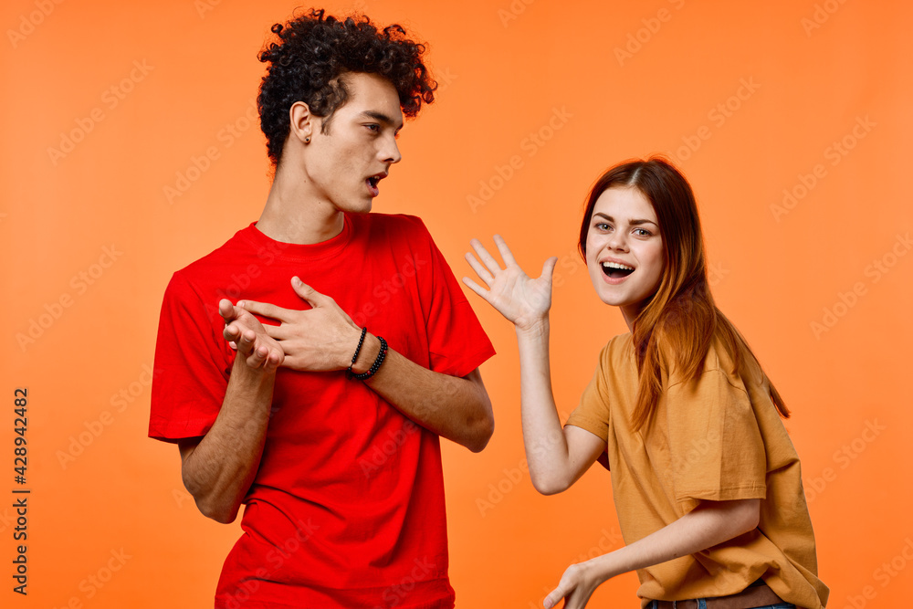 Obraz premium young couple in multicolored t-shirts joy cropped view orange background