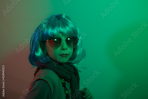 A glamour little girl posing for a photo portrait while wearing a colorful wig