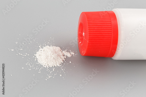 white plastic bottle of baby powder on gray background photo