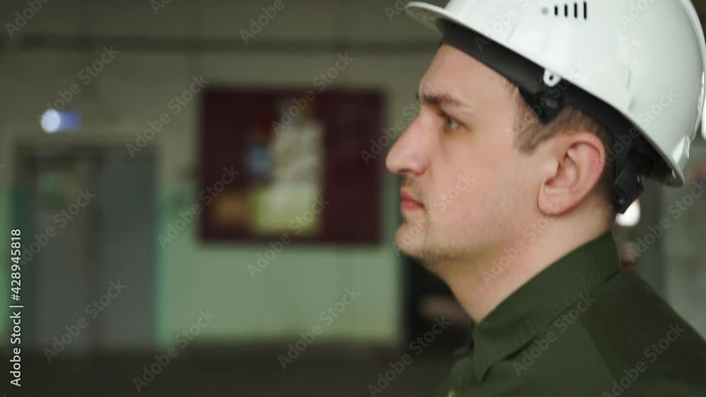 Engineer manager white protective helmet head. Walks around large hall columns supports construction site looks around checks work contractors evaluates investments. Demolition reconstruction building Engineer manager white protective helmet head. Walks around large hall columns supports construction site looks around checks work contractors evaluates investments. Demolition reconstruction building