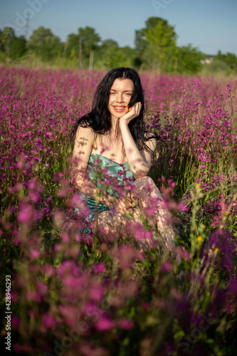 Girl in a turquoise dress in a blooming field