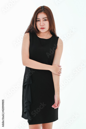A pretty young businesswoman dress up in black smart casual skirt look elegantly against white background, pose clasped hands together while smiling shyly and looking at the camera © Bangkok Click Studio