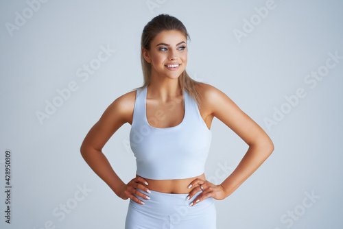 Adult beautiful woman working out over light background