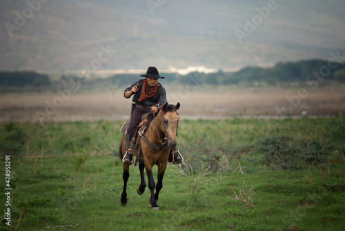 cowboy on horseback against a beautiful sunset, cowboy and horse at first light,mountain, river and lifestyle with natural light background..