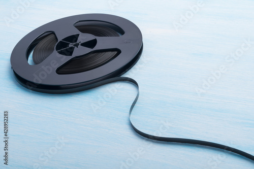 Obraz na plátně music reel with unwound magnetic film, on the blue background of the table, ther