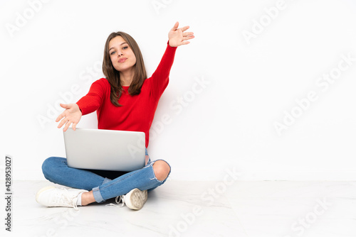 Tenaager girl working with pc isolated on white background presenting and inviting to come with hand © luismolinero