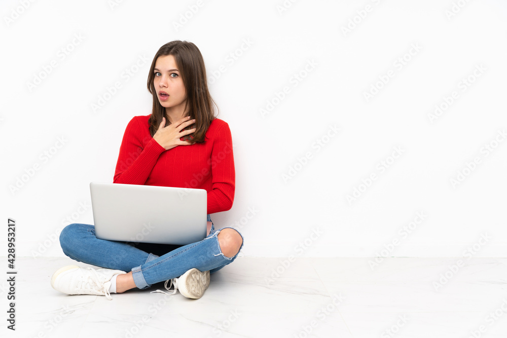 Tenaager girl working with pc isolated on white background surprised and shocked while looking right Tenaager girl working with pc isolated on white background surprised and shocked while looking right