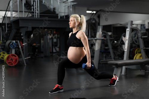 Pregnant fitness woman doing lunges exercises for leg muscle