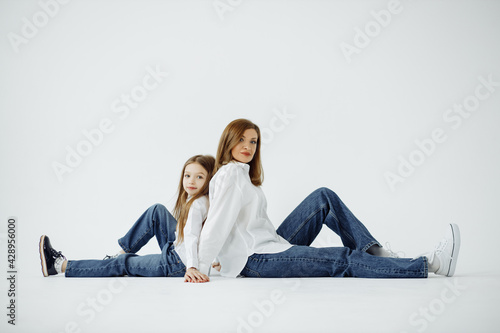 Wallpaper Mural On isolated white background mom and daughter sitting on the floor leaning back to each other, mother's day concept. Torontodigital.ca