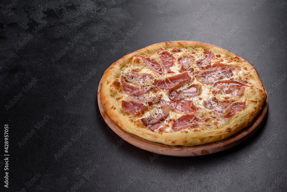 Delicious fresh crispy pizza from the oven with ham, cheese and basil