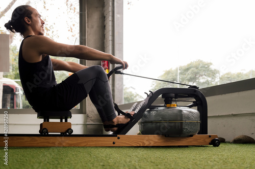 sporty man training with a water rowing machine photo