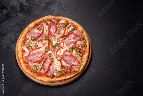 Delicious fresh crispy pizza from the oven with ham and Bulgarian pepper