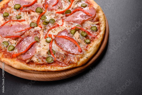 Delicious fresh crispy pizza from the oven with ham and Bulgarian pepper