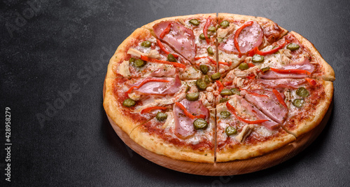 Delicious fresh crispy pizza from the oven with ham and Bulgarian pepper