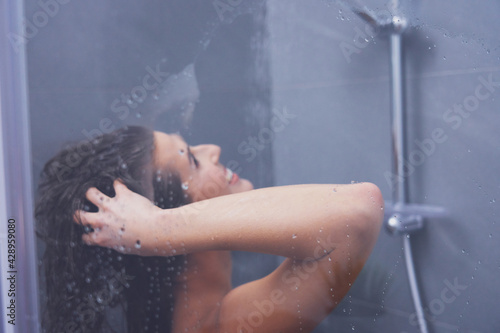 Adult woman under the shower in bathroom