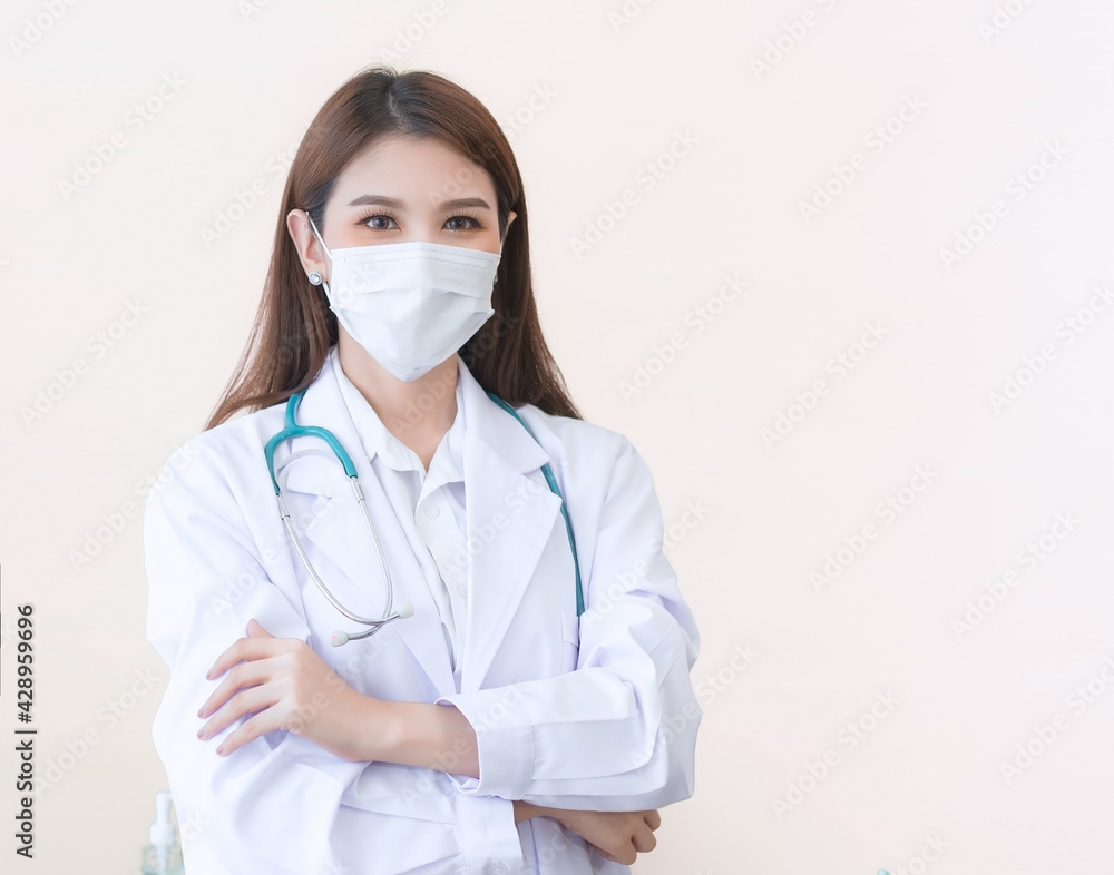 Asian female doctor stood wearing a white robe, wearing a mask and stethoscope. Asian female doctor stood wearing a white robe, wearing a mask and stethoscope.