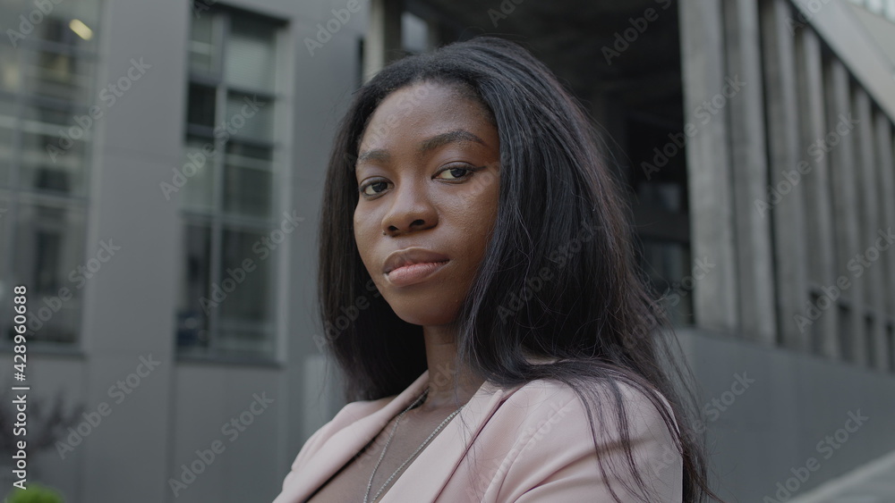 Beautiful Young Black Girl Stands On The Street. Pretty Serious Girl With Long Hair. Beautiful Young Black Girl Stands On The Street. Pretty Serious Girl With Long Hair.