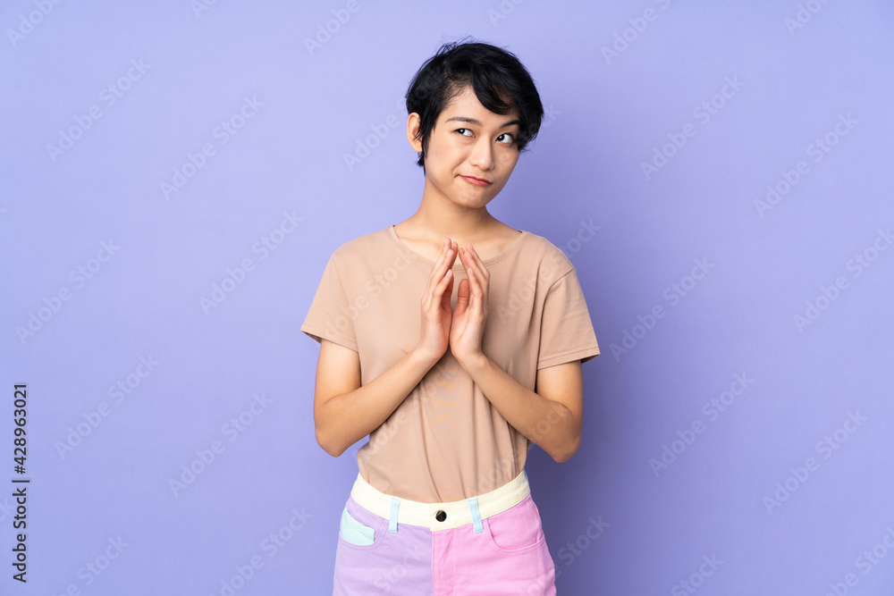 Young Vietnamese woman with short hair over isolated purple background scheming something Young Vietnamese woman with short hair over isolated purple background scheming something