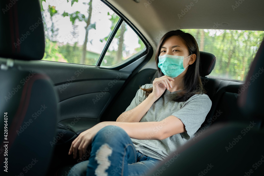 Asian woman wears a face mask to prevent COVID 19 in a car Asian woman wears a face mask to prevent COVID 19 in a car