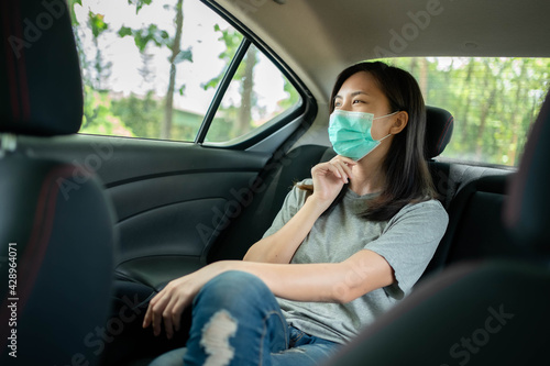 Asian woman wears a face mask to prevent COVID 19 in a car © Worranan