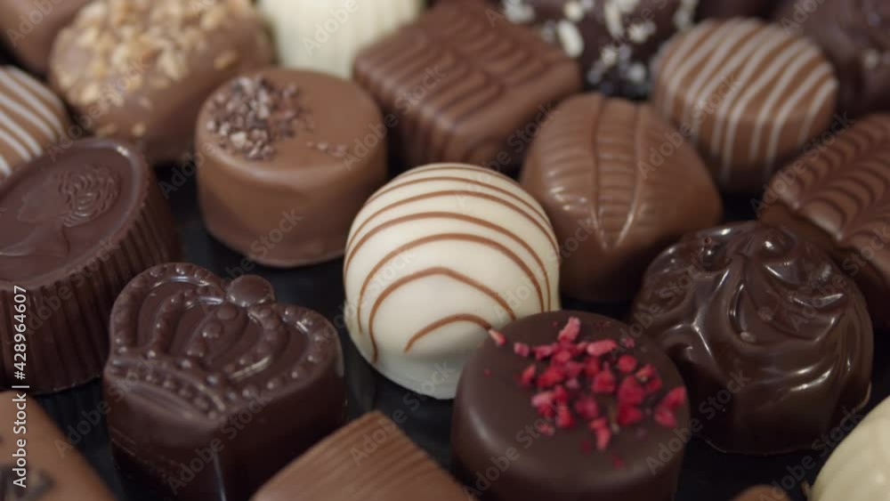 Close-up of bonbon chocolates pralines, camera moving through decorative sweets, valentines holiday gift. Close-up of bonbon chocolates pralines, camera moving through decorative sweets, valentines holiday gift.