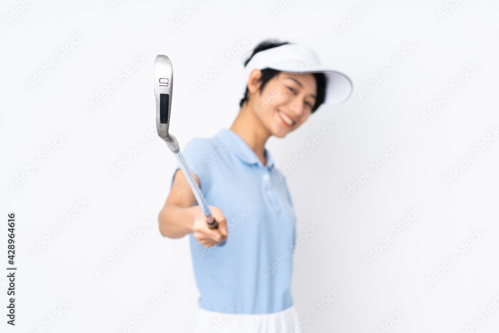 Young Vietnamese golfer woman over isolated white wall playing golf Young Vietnamese golfer woman over isolated white wall playing golf