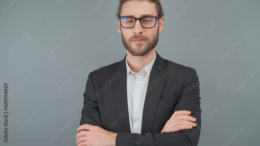 Portrait of a confident serious long-haired man in a business suit on a gray background. Portrait of a confident serious long-haired man in a business suit on a gray background.