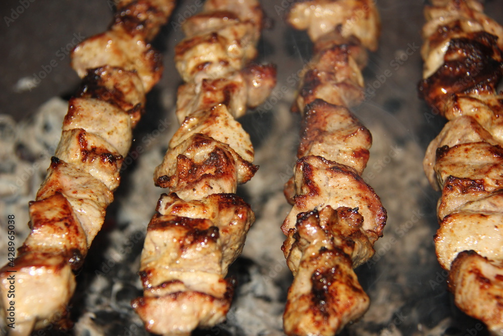 Pork or beef is fried over an open fire. Barbecue kitchen party close-up image. Selective focus.