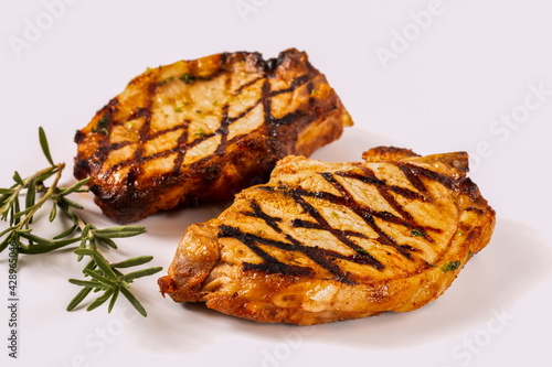 Perfectly seasoned, juicy, delicious grilled pork chops with strips sprinkled with fresh coriander.  Isolate.