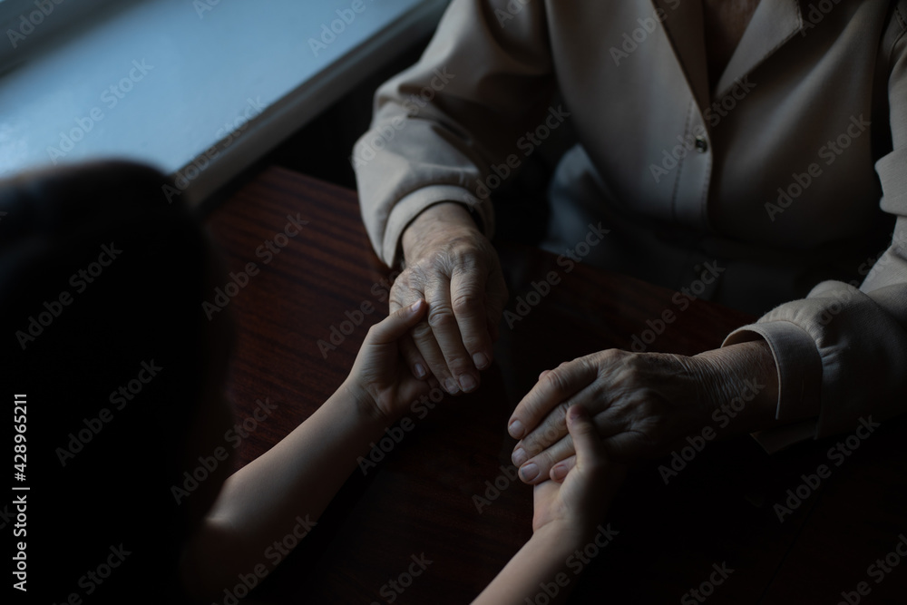 very old woman holding the hands of a child