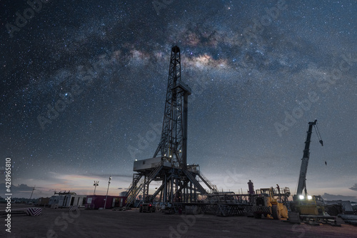 Oil drilling rig at night with milky way
