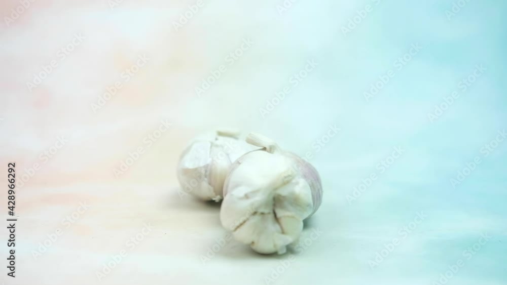 Slow motion and panning of fresh garlic rolling rolling into. Close-up. Slow motion and panning of fresh garlic rolling rolling into. Close-up.
