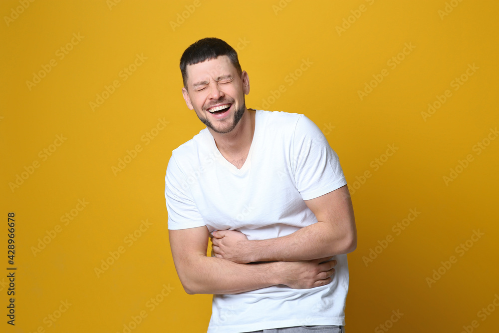 Handsome man laughing on yellow background. Funny joke Handsome man laughing on yellow background. Funny joke