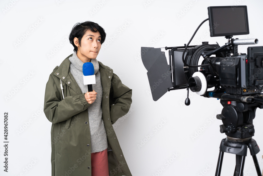 Reporter Vietnamese woman holding a microphone and reporting news and looking up