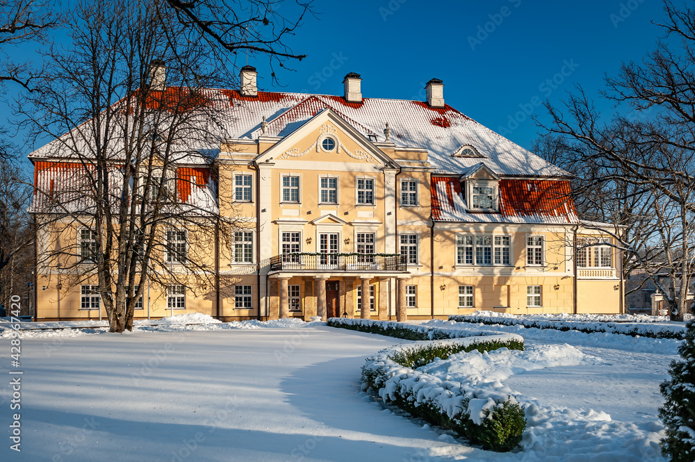 View of the Malpils manor in wintertime. Facade. The ancient manor against the background of the blue sky.