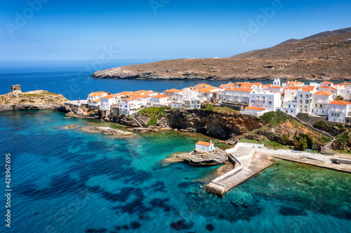 Aerial view to the beautiful town of Andros island with white houses and churches by the turquoise sea, Cyclades, Greece