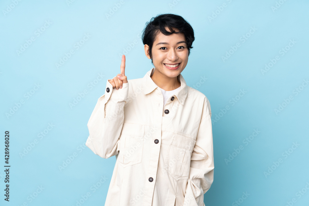 Young Vietnamese woman with short hair over isolated background pointing up a great idea Young Vietnamese woman with short hair over isolated background pointing up a great idea